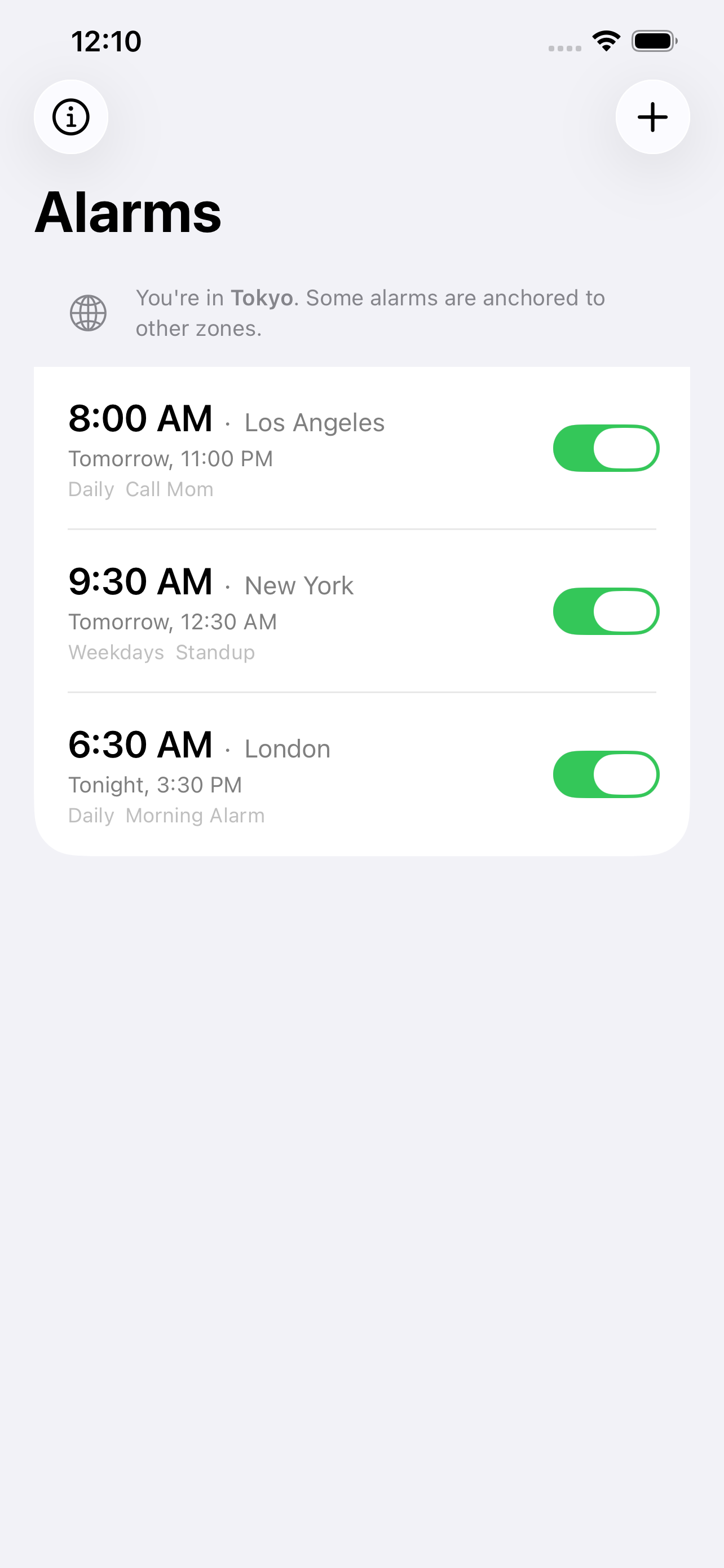 Alarm list showing three alarms anchored to Los Angeles, New York, and London — with a banner noting the device is currently in Tokyo