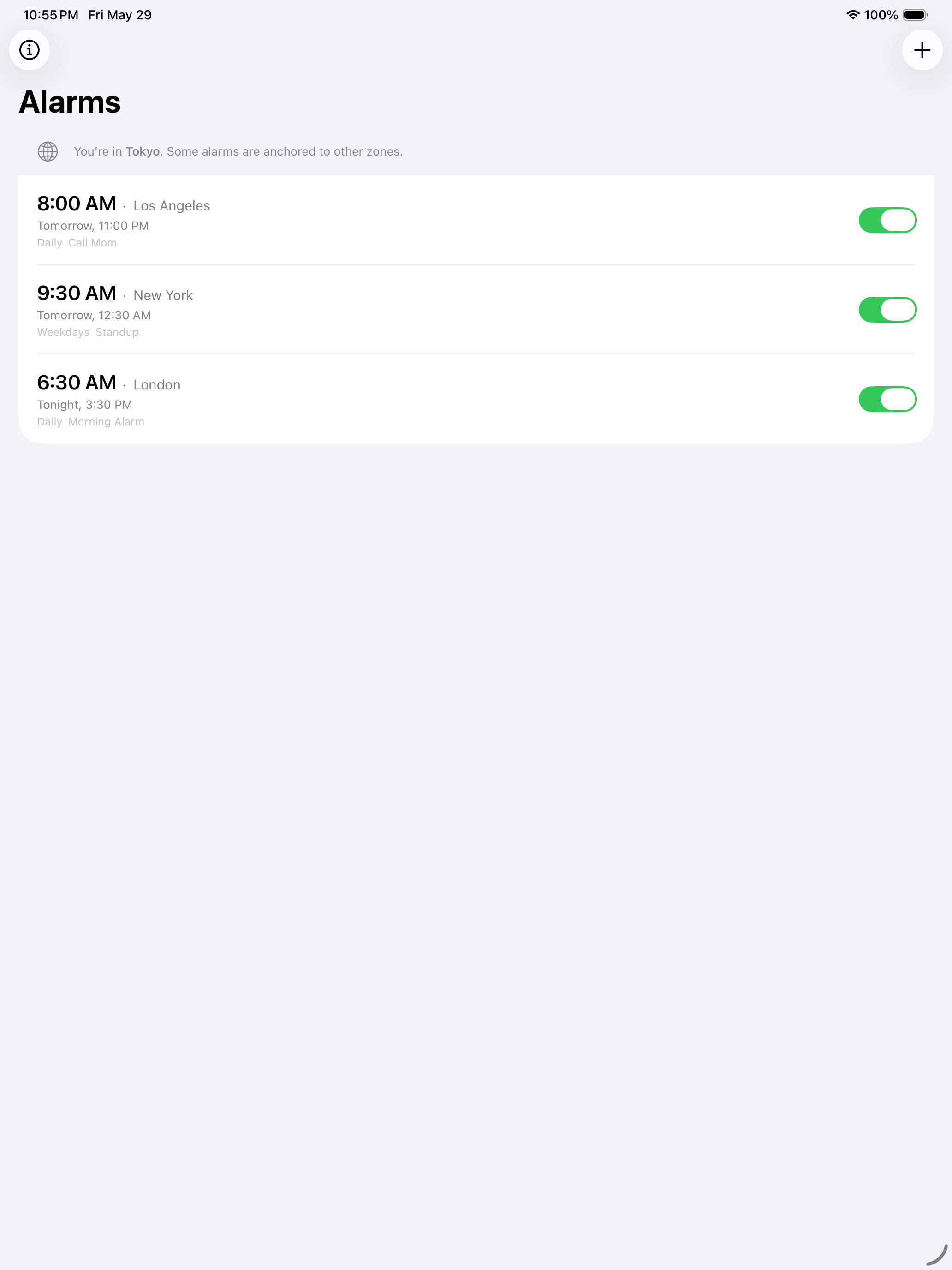 Alarm list showing three alarms anchored to Los Angeles, New York, and London — with a banner noting the device is currently in Tokyo
